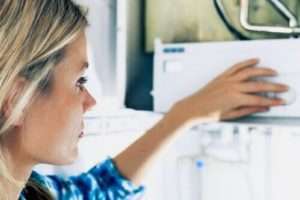 woman looking closely at a boiler