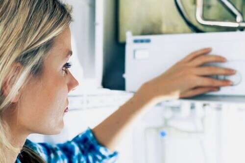 woman looking closely at a boiler